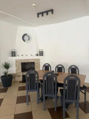 a dining room with a table and chairs and a fireplace at Kompleks Rekreacyjno-Wypoczynkowy i Restauracja STRUMYK in Jordanów