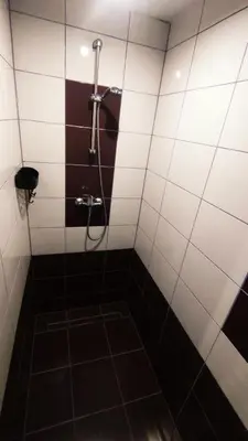 a bathroom with a shower with black and white tiles at Kompleks Rekreacyjno-Wypoczynkowy i Restauracja STRUMYK in Jordanów
