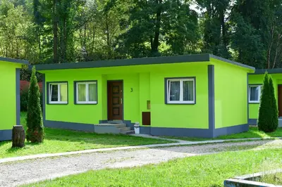 a small green house with a driveway at Kompleks Rekreacyjno-Wypoczynkowy i Restauracja STRUMYK in Jordanów
