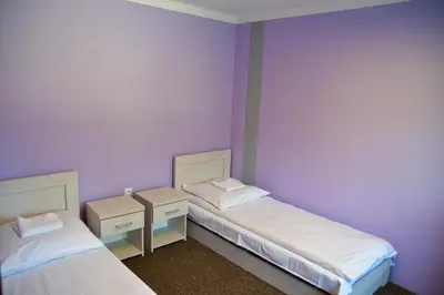 two beds in a room with purple walls at Kompleks Rekreacyjno-Wypoczynkowy i Restauracja STRUMYK in Jordanów
