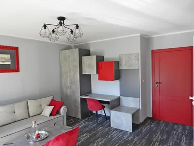 a living room with a couch and a red door at Apartament A2D Kraków in Kraków