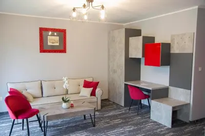 a living room with a couch and red chairs at Apartament A2D Kraków in Kraków
