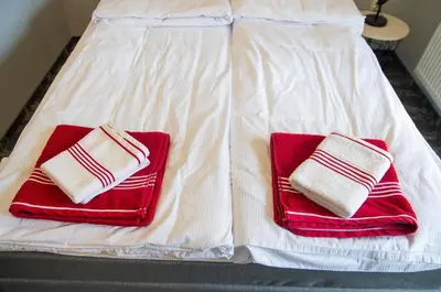 two red and white towels sitting on a bed at Apartament A2D Kraków in Kraków