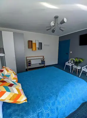 a bedroom with a large blue bed with a ceiling fan at Apartament A2D Kraków in Kraków