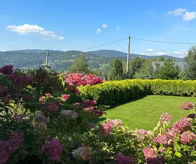 a garden with pink and purple flowers and bushes at Rezydencja Zawoja in Zawoja