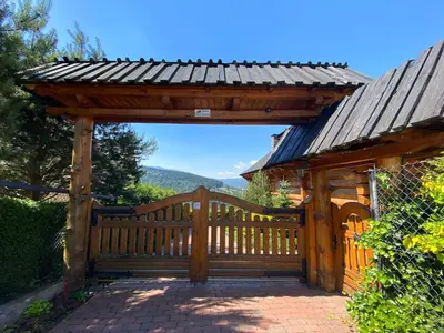 a wooden pergola with a gate and a fence at Rezydencja Zawoja in Zawoja