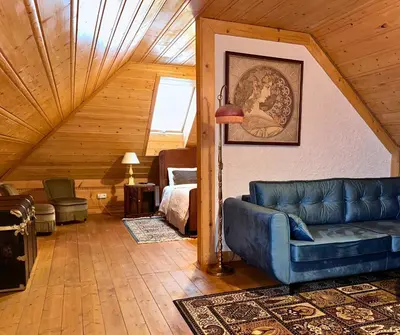a living room with a blue couch and a bedroom at Rezydencja Zawoja in Zawoja