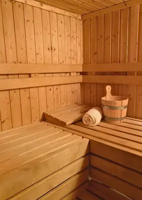 a wooden sauna with two beds and a tub at Rezydencja Zawoja in Zawoja