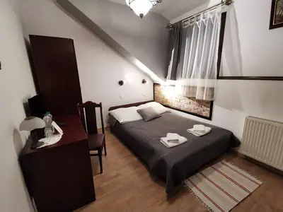a small bedroom with a bed and a desk at Dworek Złoty Róg Hotel i Restauracja in Kraków