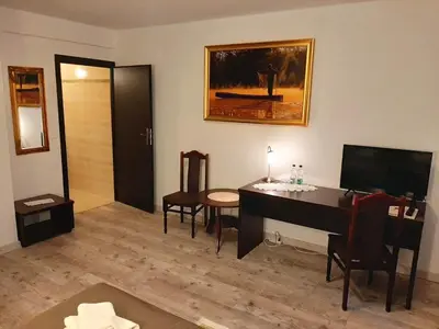 a living room with a desk and a television at Dworek Złoty Róg Hotel i Restauracja in Kraków