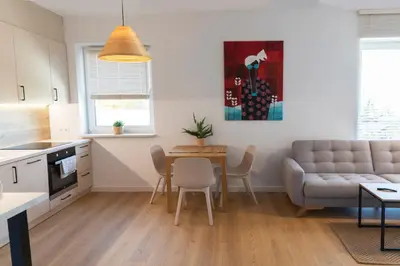 a kitchen and living room with a couch and a table at Apartamenty na Wzgórzu in Bochnia
