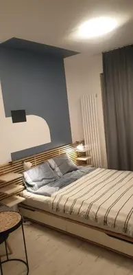 a bedroom with a bed and a blue wall at Apartamenty na Wzgórzu in Bochnia