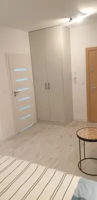 an empty room with a table and some doors at Apartamenty na Wzgórzu in Bochnia
