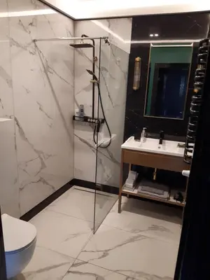 a bathroom with a shower and a sink and a toilet at KR47 Kossak Residence in Kraków