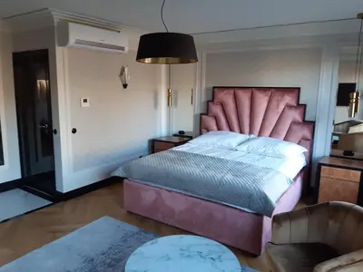 a bedroom with a large bed with a pink headboard at KR47 Kossak Residence in Kraków