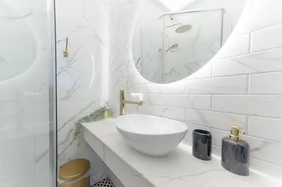 a white bathroom with a sink and a mirror at Boleslav Home De Luxe in Sucha Beskidzka