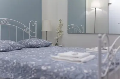 a bedroom with a blue bed with a mirror at Boleslav Home De Luxe in Sucha Beskidzka