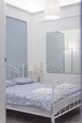 a white bedroom with a bed with a blue comforter at Boleslav Home De Luxe in Sucha Beskidzka