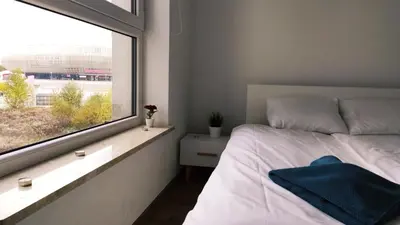 a bedroom with a bed and a large window at Dąbska 26 by Homeprime in Kraków