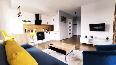 a living room with a blue couch and a table at Dąbska 26 by Homeprime in Kraków