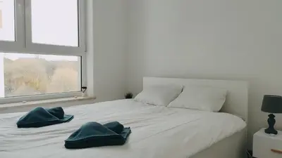 a bedroom with a bed with two blue towels on it at Dąbska 26 by Homeprime in Kraków