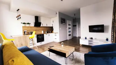 a living room with a blue couch and a table at Dąbska 26 by Homeprime in Kraków
