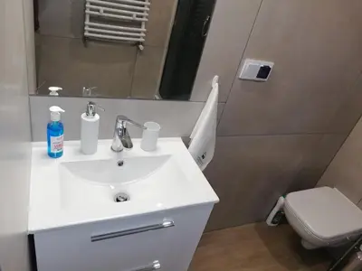 a bathroom with a white sink and a toilet at Apartament nad Gorczańskim Strumieniem in Koninki