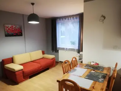 a living room with a couch and a table at Apartament nad Gorczańskim Strumieniem in Koninki