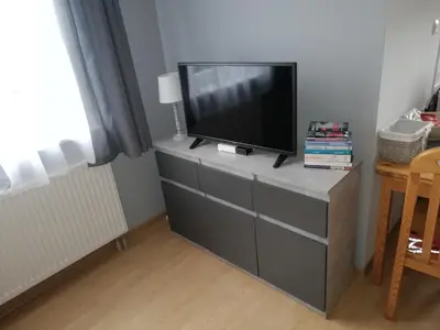 a flat screen tv sitting on top of a dresser at Apartament nad Gorczańskim Strumieniem in Koninki