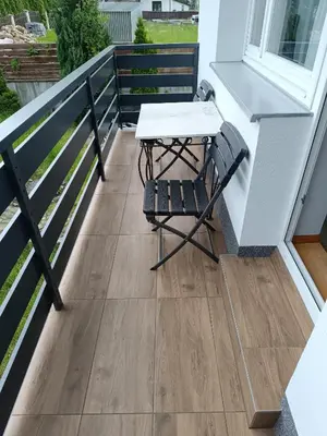 a table and a chair on a balcony at Apartament nad Gorczańskim Strumieniem in Koninki