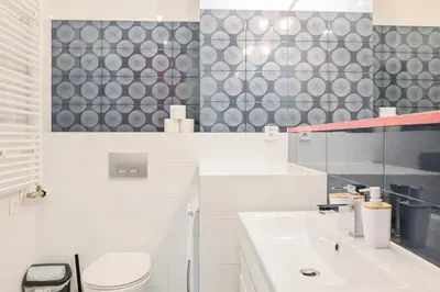 a white bathroom with a toilet and a sink at D&A Apartments Pawia in Kraków
