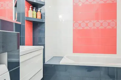 a bathroom with a white sink and red tiles at D&A Apartments Pawia in Kraków