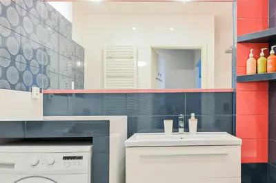 a bathroom with a sink and a washing machine at D&A Apartments Pawia in Kraków