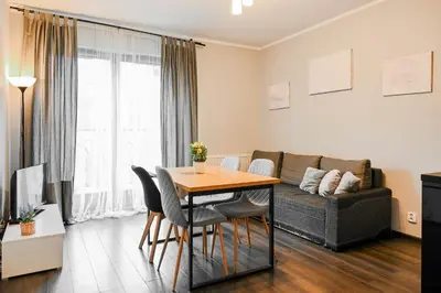 a living room with a table and a couch at D&A Apartments Pawia in Kraków