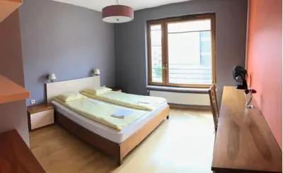 a bedroom with a large bed and a window at Apartment on the Boulvard in Kraków