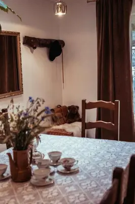 a dining room table with a vase of flowers on it at Dom Pod Lasem 44 in Klecza Górna