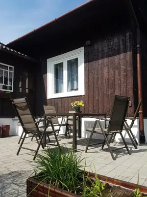 a patio with chairs and a table and a building at Dom Pod Lasem 44 in Klecza Górna