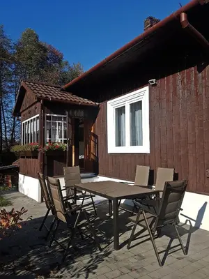 a table and chairs in front of a house at Dom Pod Lasem 44 in Klecza Górna