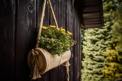 a flower pot hanging on the side of a building at Dom Pod Lasem 44 in Klecza Górna