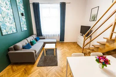 a living room with a couch and a tv at VINTAGE SZPITALNA APARTMENT in Kraków