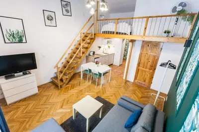 a living room with a couch and a staircase at VINTAGE SZPITALNA APARTMENT in Kraków