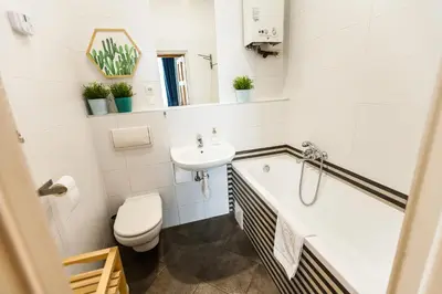 a bathroom with a sink and a tub and a toilet at VINTAGE SZPITALNA APARTMENT in Kraków