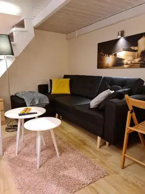 a living room with a black couch and a table at AMBER APATRTAMENt 7 in Kraków