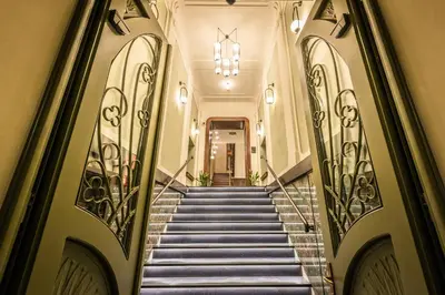 a staircase leading to a building with a chandelier at Liebeskind Boutique Hotel Old Town in Kraków