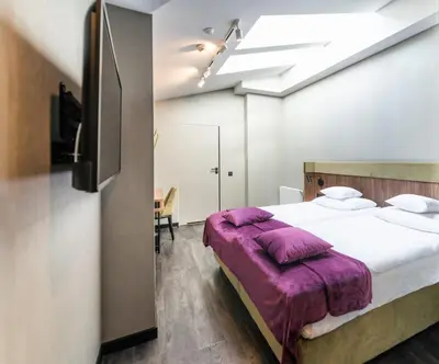 a bedroom with a large bed with a purple blanket at Liebeskind Boutique Hotel Old Town in Kraków
