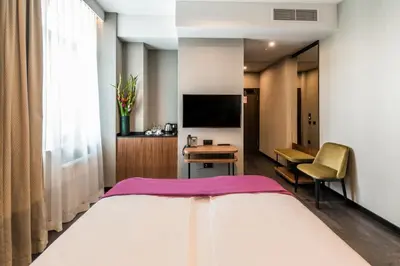 a hotel room with a bed and a desk and a tv at Liebeskind Boutique Hotel Old Town in Kraków