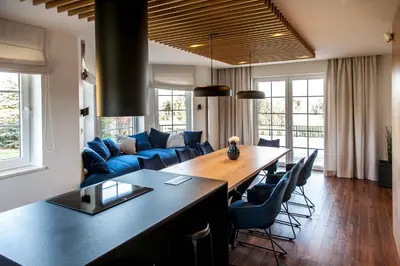 a living room with a table and a blue couch at Willa pod Lanckoroną in Izdebnik