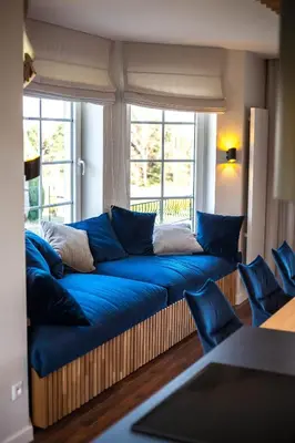 a large blue couch in a room with a window at Willa pod Lanckoroną in Izdebnik