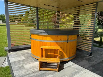 a wooden barrel sitting on a patio with a table at Willa pod Lanckoroną in Izdebnik