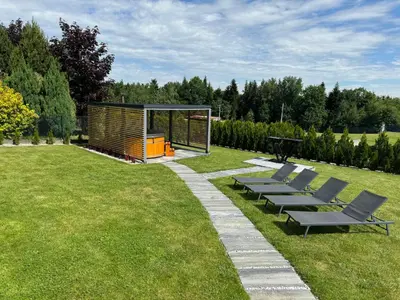a group of benches in a field with a gazebo at Willa pod Lanckoroną in Izdebnik